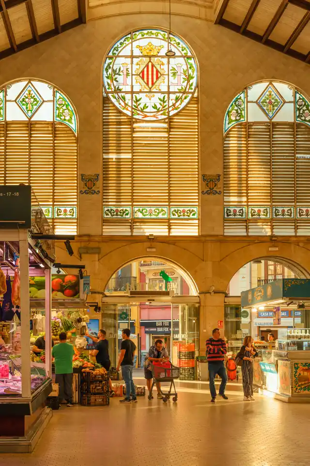 Interior of Mercado Central in Valencia with stained-glass windows and market stalls