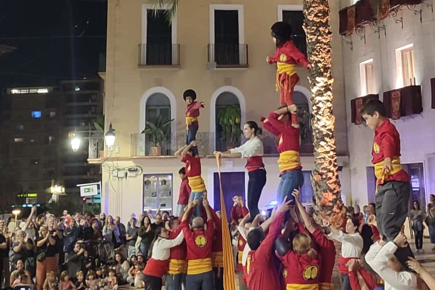 Muixeranga human towers rising in a town square at night, a living Valencian festival tradition