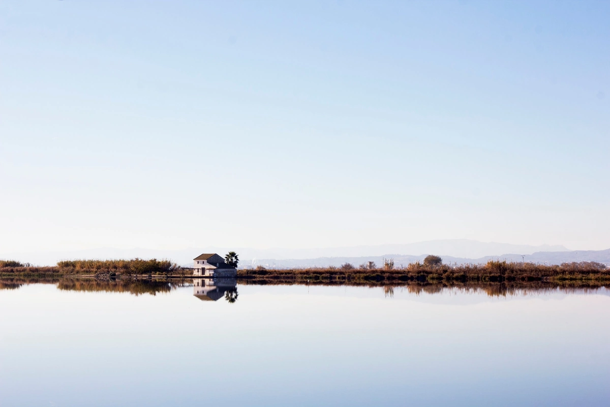 A farmhouse reflected in the flooded rice fields of the Albufera Natural Park
